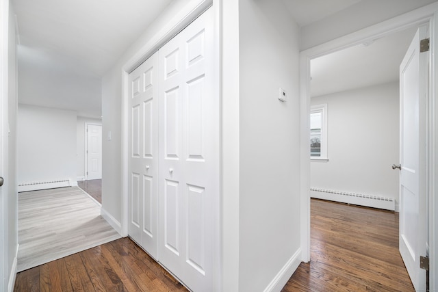 hall with baseboard heating and dark hardwood / wood-style flooring