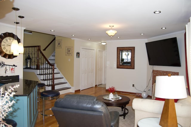 living room with ornamental molding and light hardwood / wood-style floors