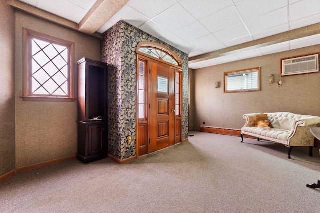 foyer featuring a paneled ceiling, a wall mounted air conditioner, and carpet flooring