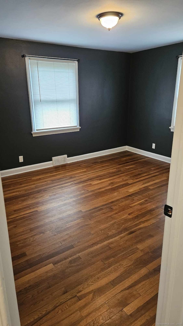 empty room with dark hardwood / wood-style flooring