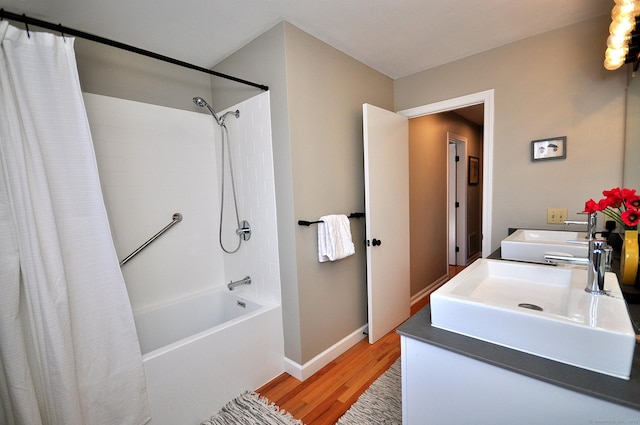 bathroom featuring shower / bath combo with shower curtain, wood-type flooring, and sink