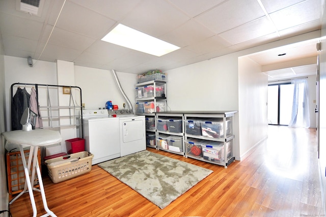 laundry area with washer and dryer and light hardwood / wood-style flooring