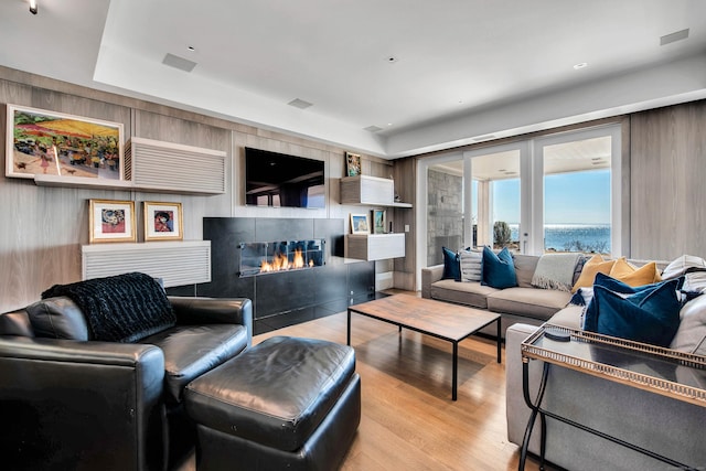 living room featuring a tile fireplace and light hardwood / wood-style floors