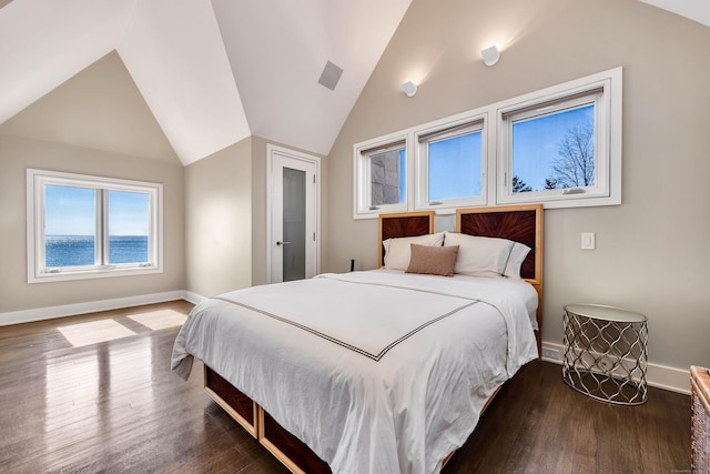 bedroom featuring hardwood / wood-style floors, a water view, and lofted ceiling