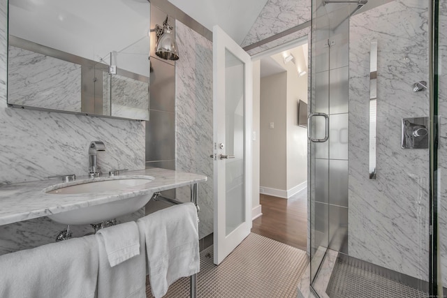 bathroom with lofted ceiling, tile patterned flooring, walk in shower, and sink