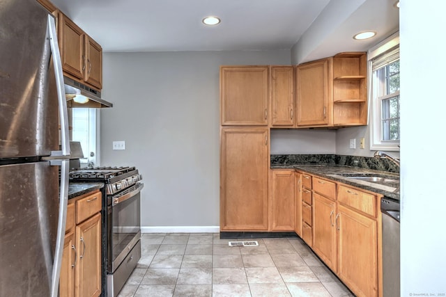 kitchen with sink, dark stone countertops, light tile patterned floors, and appliances with stainless steel finishes