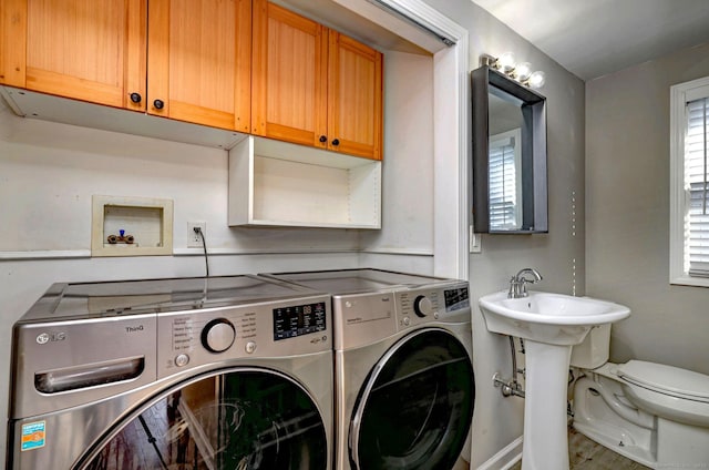 laundry area featuring sink, cabinets, and washing machine and clothes dryer