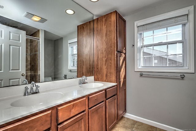 bathroom with toilet, tile patterned flooring, vanity, and a healthy amount of sunlight