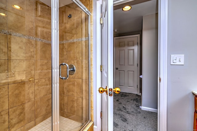 bathroom featuring a shower with shower door and vanity