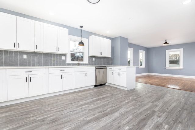 kitchen with white cabinetry, pendant lighting, dishwasher, and kitchen peninsula