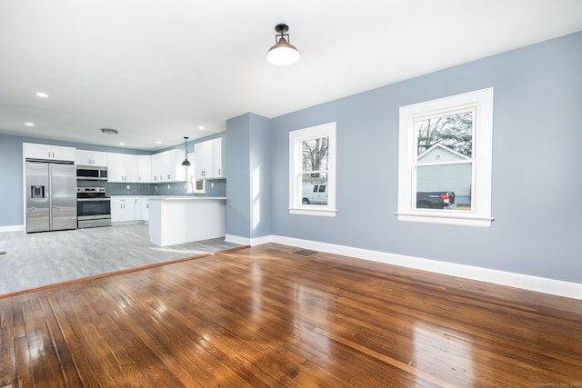 unfurnished living room with sink and light hardwood / wood-style flooring