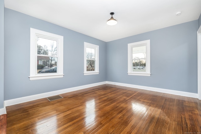 spare room with wood-type flooring and a wealth of natural light