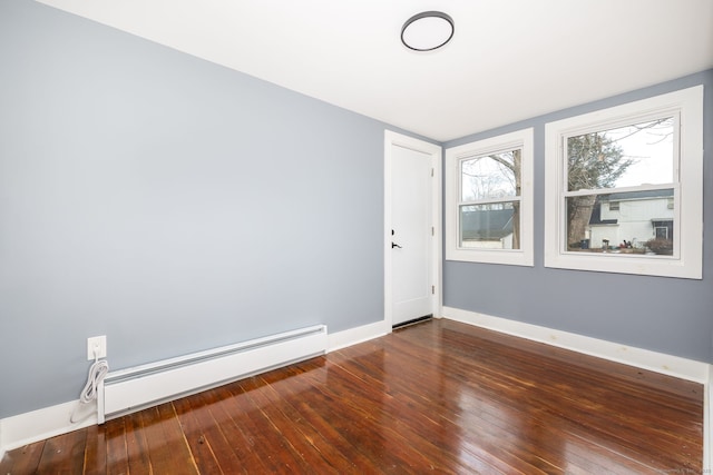 empty room with dark hardwood / wood-style flooring and a baseboard radiator