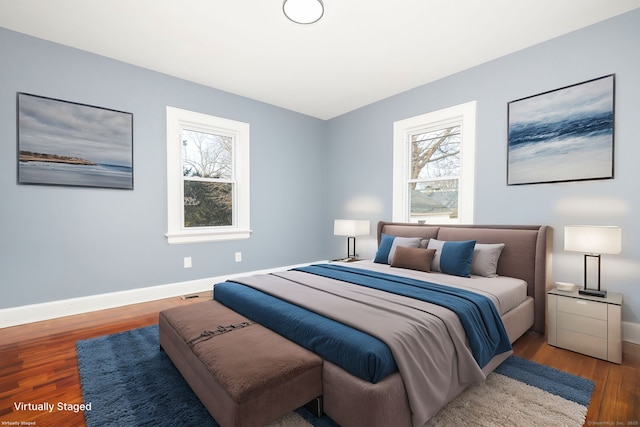 bedroom with multiple windows and wood-type flooring