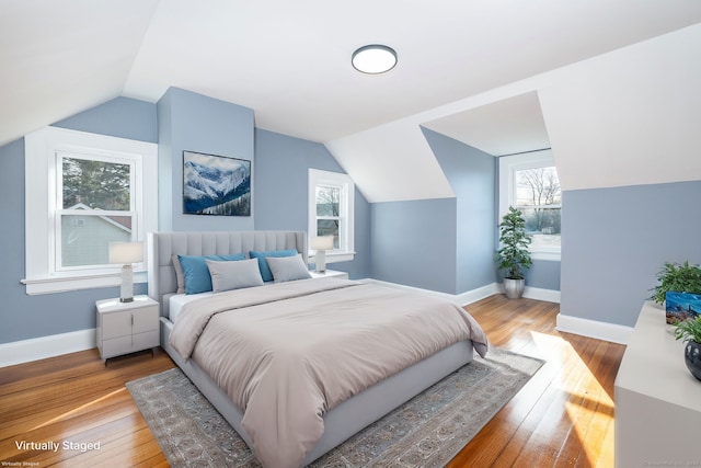 bedroom with light wood-type flooring and lofted ceiling