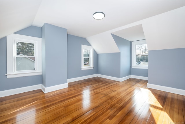 additional living space featuring lofted ceiling and hardwood / wood-style floors