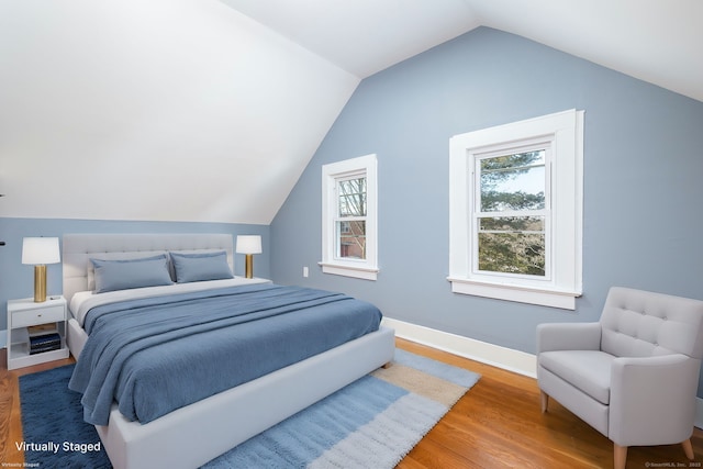 bedroom with lofted ceiling and hardwood / wood-style flooring