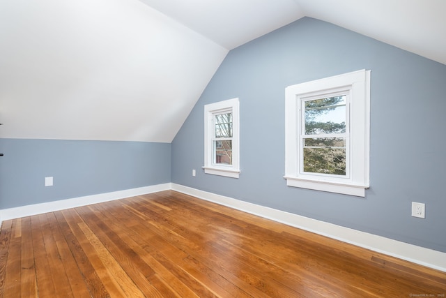 additional living space featuring vaulted ceiling and wood-type flooring