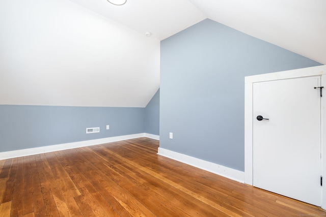 additional living space featuring lofted ceiling and hardwood / wood-style flooring