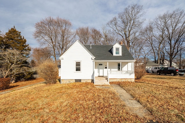 new england style home featuring a front yard and covered porch