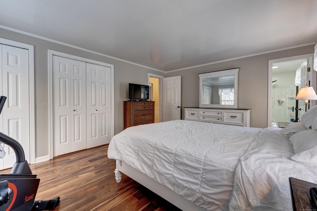 bedroom with multiple closets, crown molding, and dark hardwood / wood-style floors