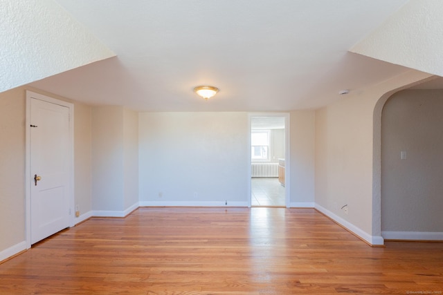 empty room with radiator and light wood-type flooring