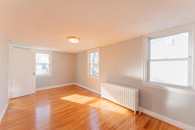 spare room with light hardwood / wood-style flooring and radiator heating unit