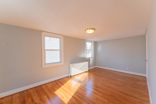 spare room with light wood-type flooring and radiator