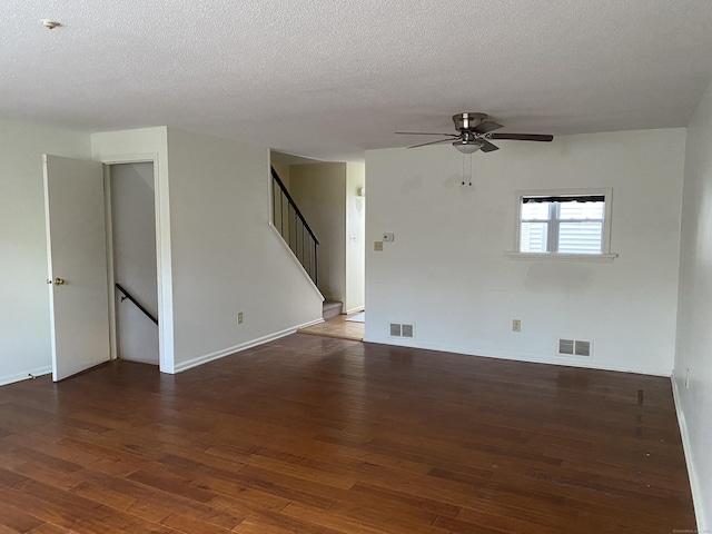 unfurnished room with a textured ceiling, ceiling fan, and dark hardwood / wood-style floors