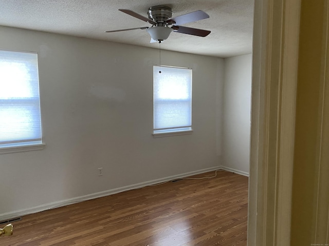 unfurnished room with ceiling fan, a textured ceiling, and hardwood / wood-style flooring