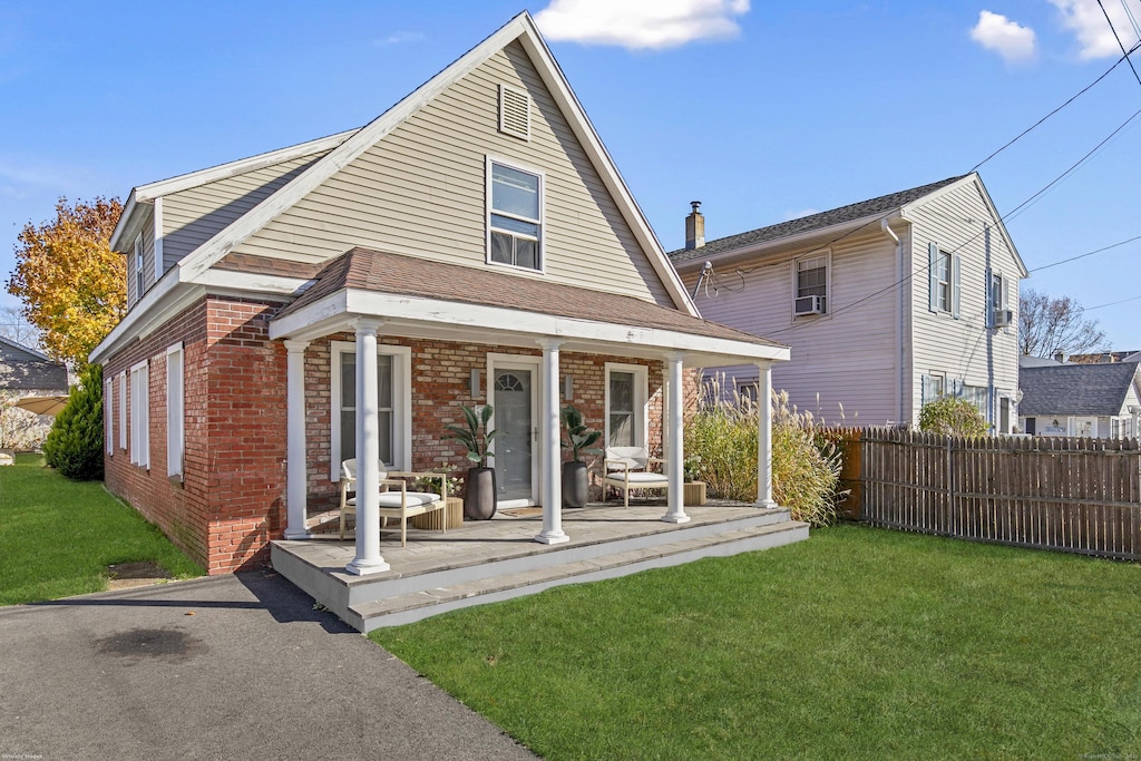 rear view of property with a yard and covered porch