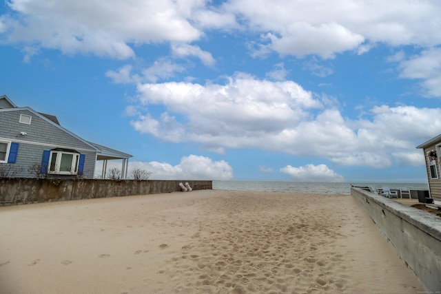 view of yard featuring a water view and a beach view