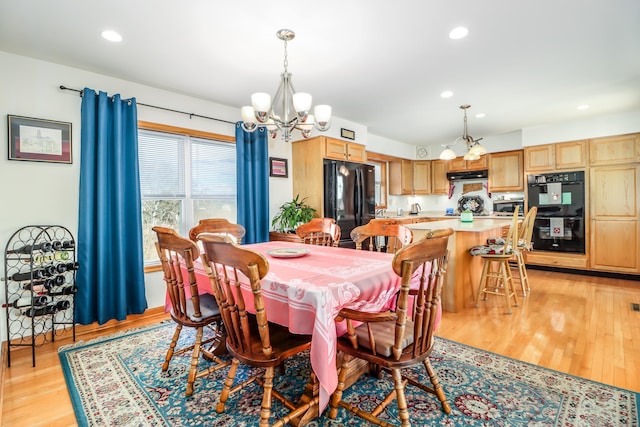 dining room with an inviting chandelier and light hardwood / wood-style flooring