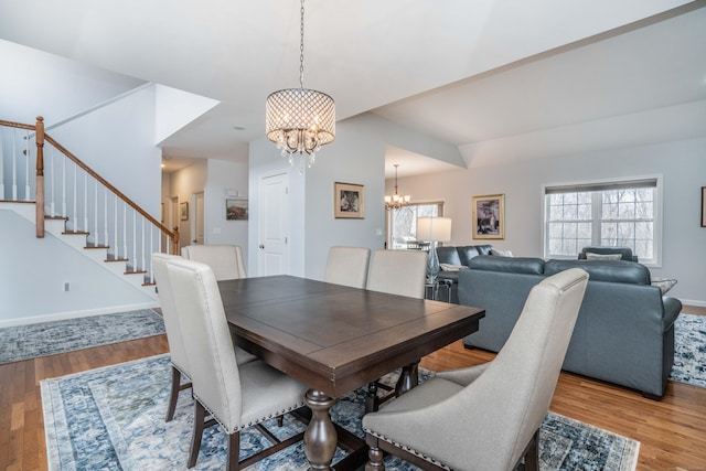 dining area with wood-type flooring and a notable chandelier