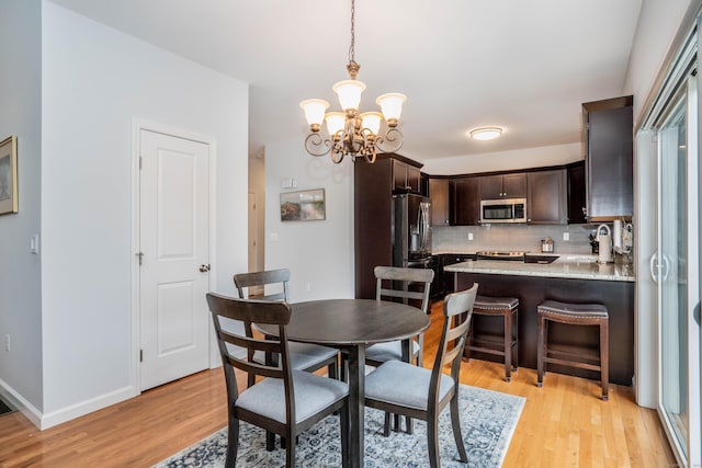 dining room with a chandelier and light hardwood / wood-style flooring