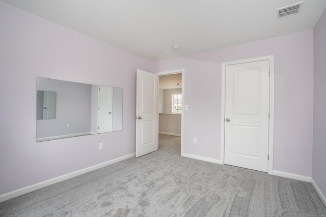 unfurnished bedroom with light colored carpet and electric panel