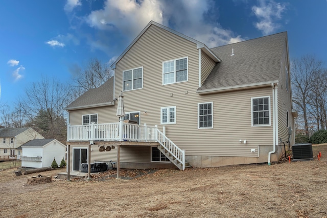 rear view of property with a deck, central AC, and a yard