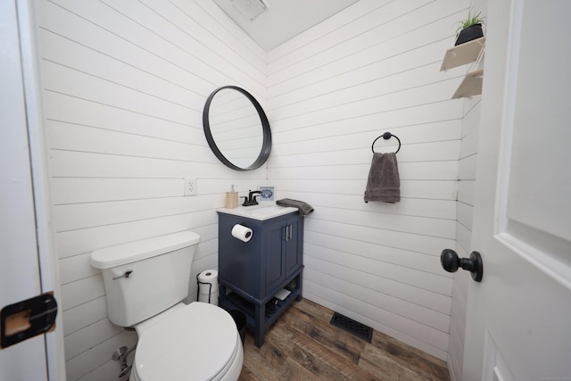 bathroom with toilet, hardwood / wood-style floors, and vanity