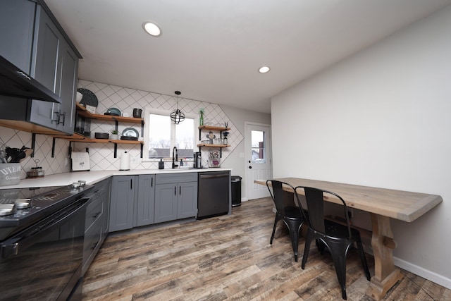 kitchen featuring gray cabinetry, decorative light fixtures, wood-type flooring, black appliances, and sink