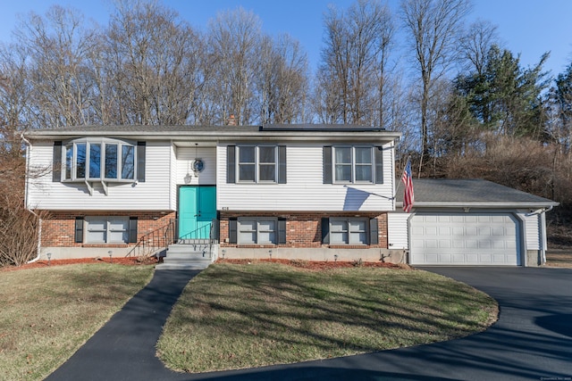 raised ranch with a garage and a front yard