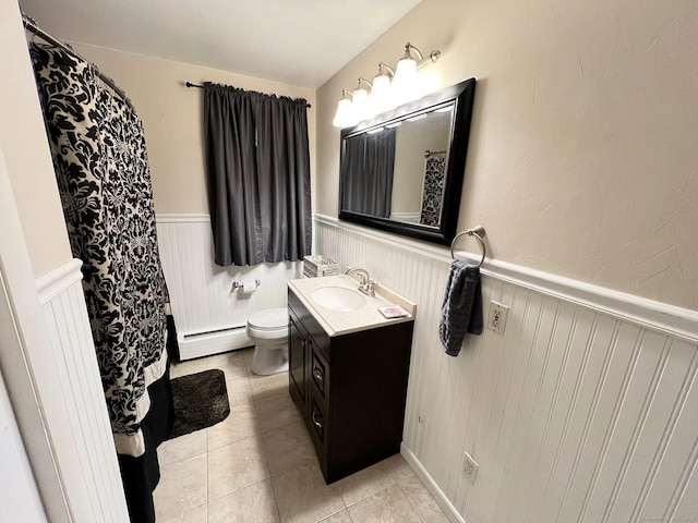 bathroom with tile patterned floors, a baseboard heating unit, vanity, and toilet