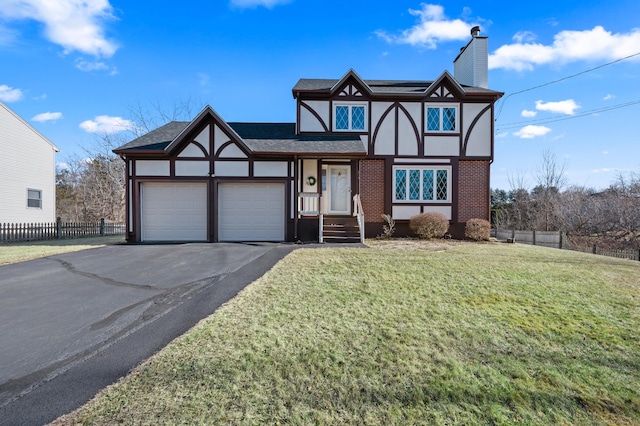 tudor home with a front lawn and a garage