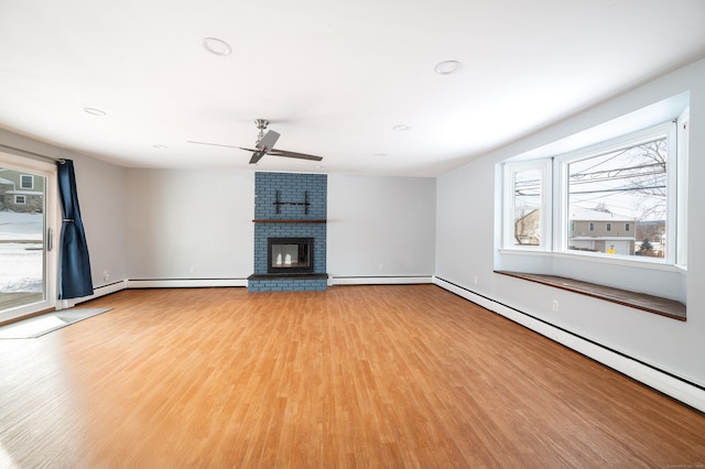 unfurnished living room featuring a fireplace, baseboard heating, light hardwood / wood-style flooring, and ceiling fan