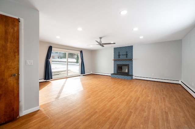 unfurnished living room featuring a fireplace, light hardwood / wood-style floors, a baseboard heating unit, and ceiling fan