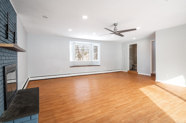 unfurnished living room with ceiling fan, a brick fireplace, a baseboard heating unit, and light hardwood / wood-style floors