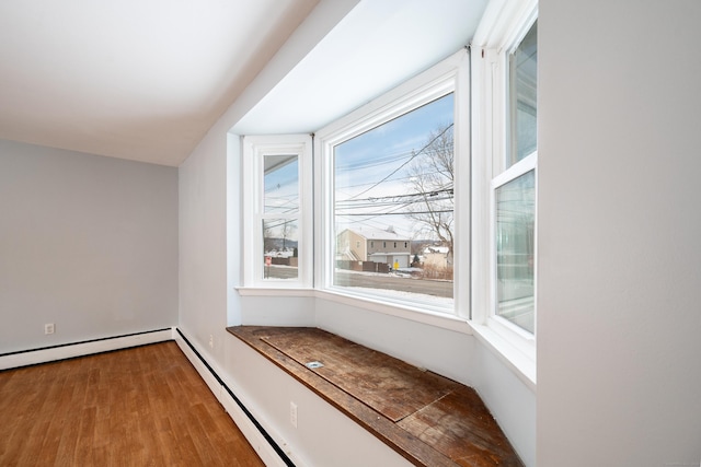 bonus room featuring hardwood / wood-style floors and a baseboard heating unit