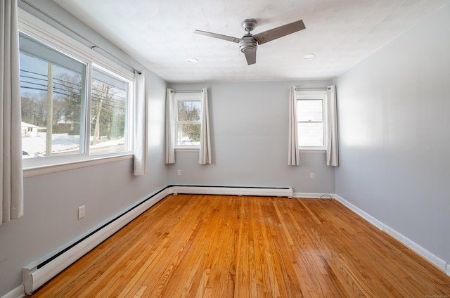 spare room with baseboard heating, light hardwood / wood-style floors, and plenty of natural light