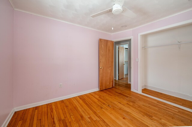 unfurnished bedroom featuring ceiling fan, hardwood / wood-style flooring, a closet, and ornamental molding