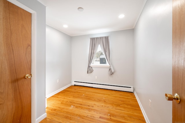 spare room featuring a baseboard radiator and hardwood / wood-style flooring