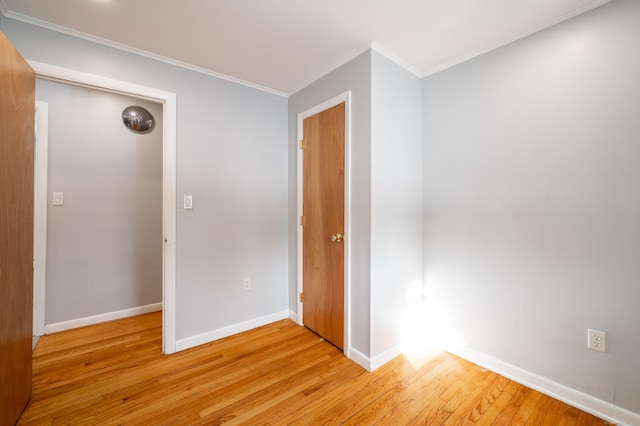 spare room featuring light hardwood / wood-style floors and ornamental molding